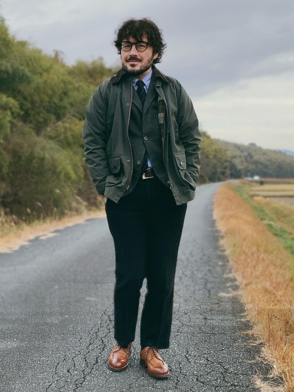 グリーン系のその他アウター、グレー系のテーラードジャケット、ブラック系のスラックスを着用したメンズの冬コーディネートの4枚目の写真