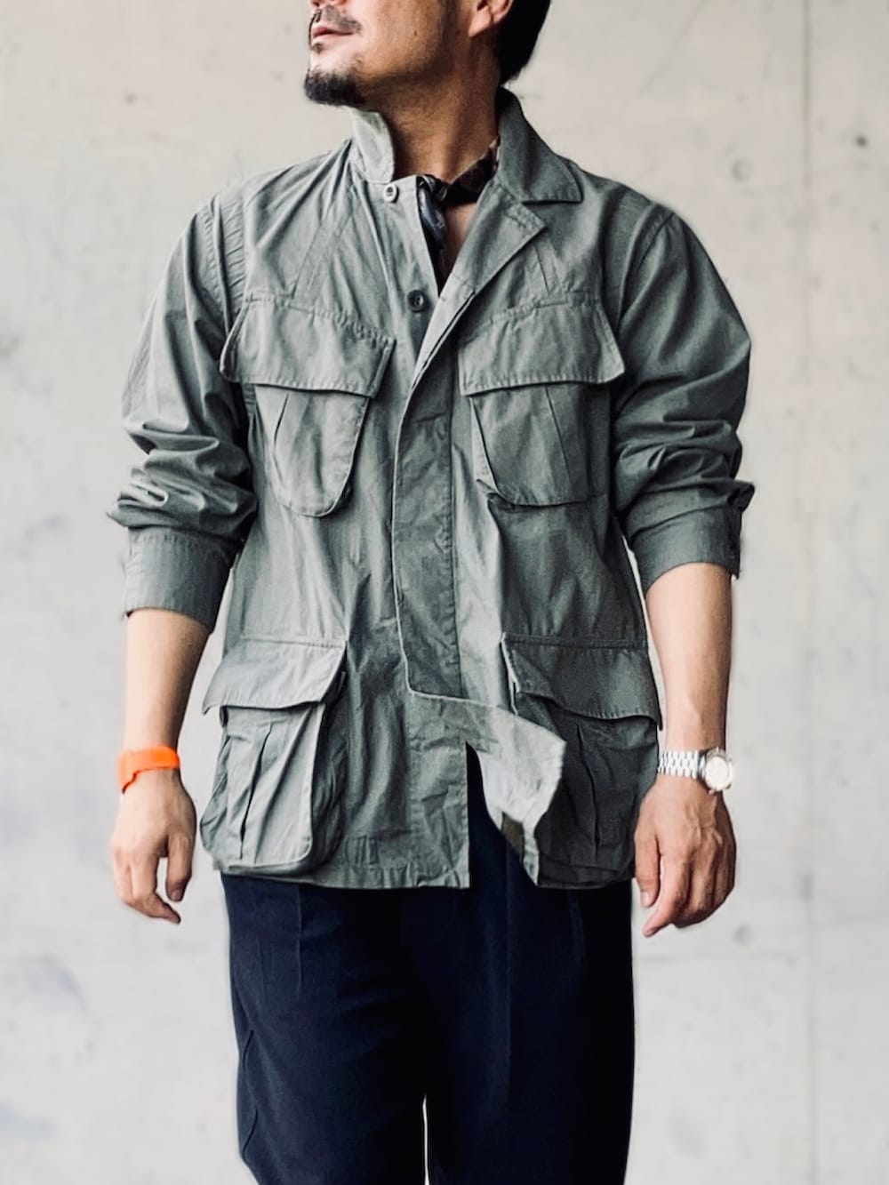 グリーン系のミリタリージャケット、ブルー系のスラックス、ブラウン系のローファーを着用したメンズの秋コーディネートの3枚目の写真