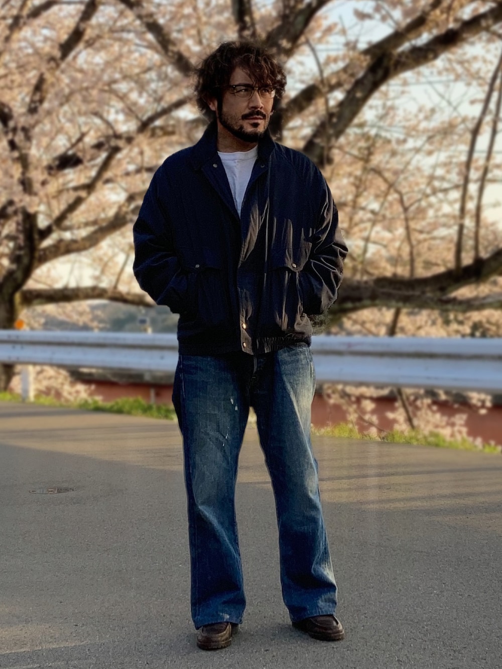 ホワイト系のTシャツ/カットソー、グレー系のブルゾン、ブルー系のデニムパンツを着用したメンズの春コーディネートの2枚目の写真