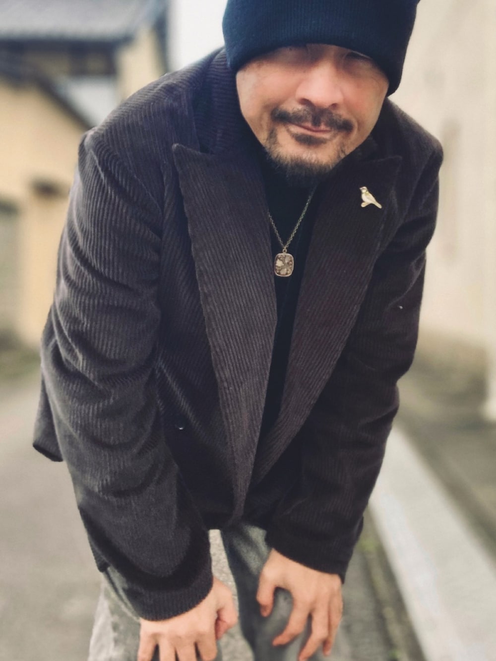 ブラック系のニット/セーター、グレー系のテーラードジャケット、グレー系のデニムパンツを着用したメンズの冬コーディネートの5枚目の写真