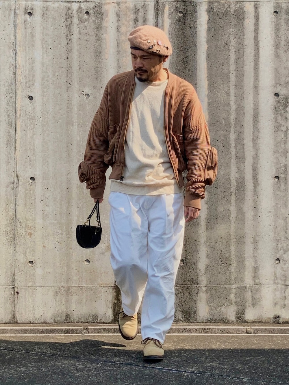 ベージュ系のニット/セーター、ブラウン系のMA-1、ホワイト系のスラックスを着用したメンズの春コーディネートの3枚目の写真