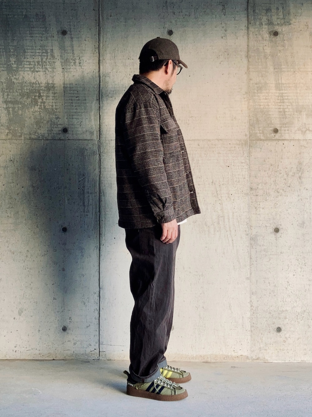 ホワイト系のTシャツ/カットソー、ブラウン系のブルゾン、ブラウン系のデニムパンツを着用したメンズの冬コーディネートの3枚目の写真