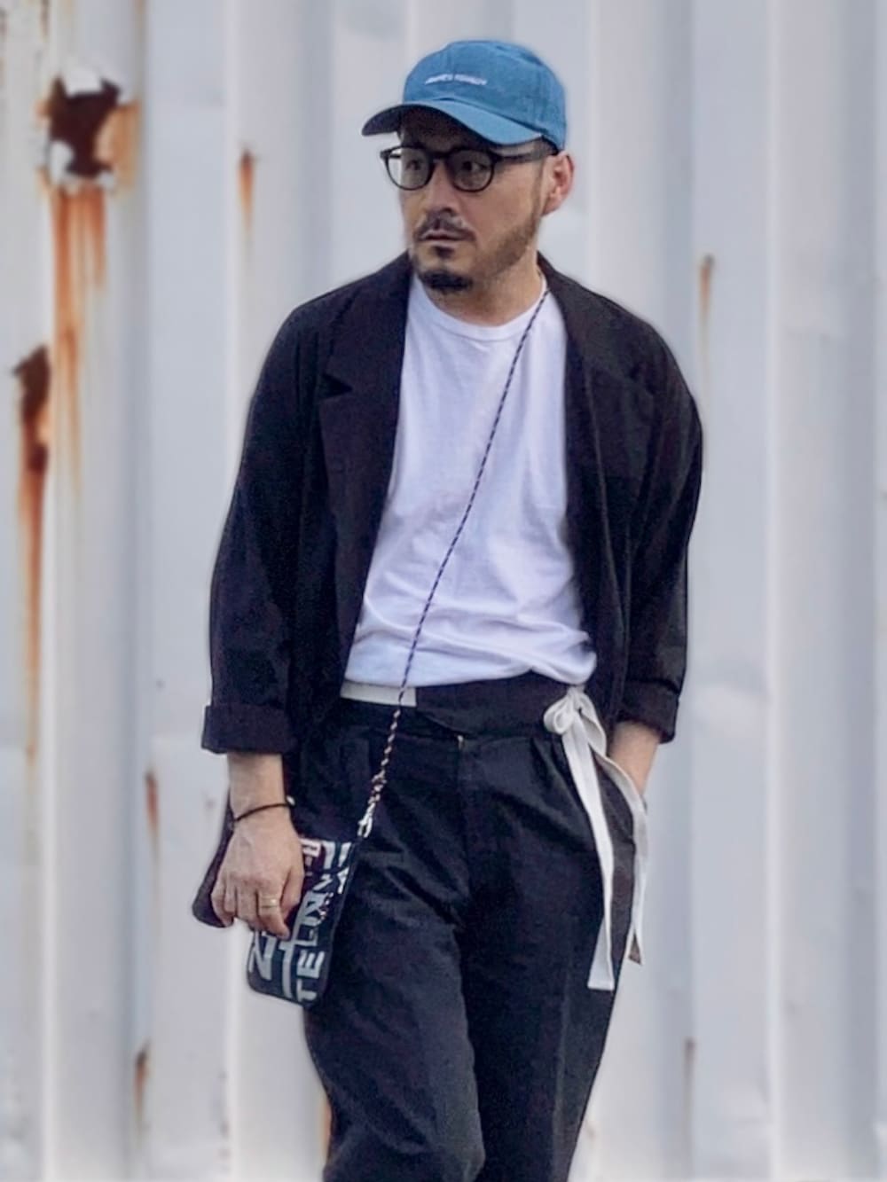 ホワイト系のTシャツ/カットソー、ブラック系のテーラードジャケット、ブラック系のその他パンツを着用したメンズの夏コーディネートの3枚目の写真