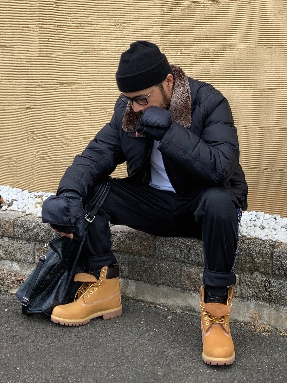 ブラック系のダウンジャケット/コート、ブラック系のスウェットパンツ、イエロー系のブーツを着用したメンズの冬コーディネートの3枚目の写真