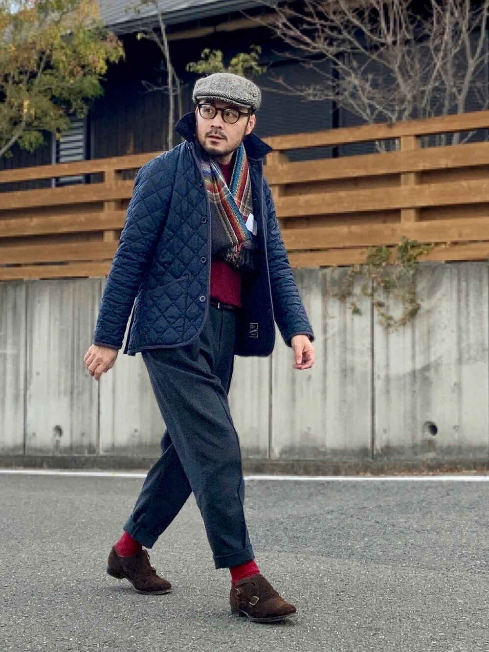 レッド系のニット/セーター、ブルー系のその他アウター、グレー系のスラックスを着用したメンズの冬コーディネートの4枚目の写真