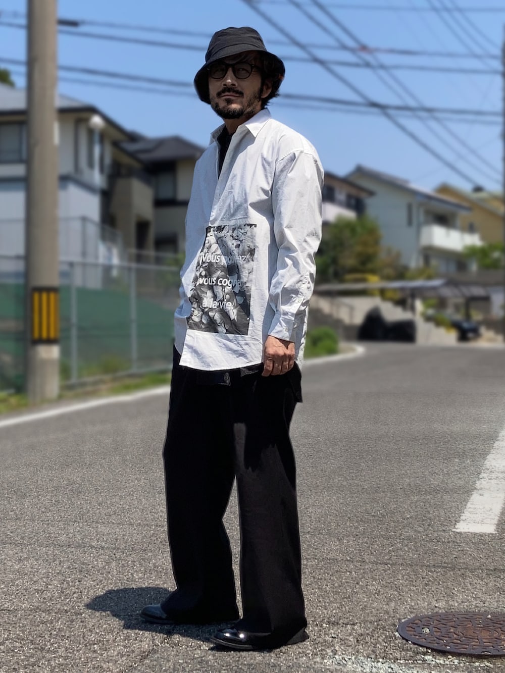 ホワイト系のシャツ/ブラウス、ブラック系のスラックス、ブラック系のブーツを着用したメンズの春コーディネートの2枚目の写真