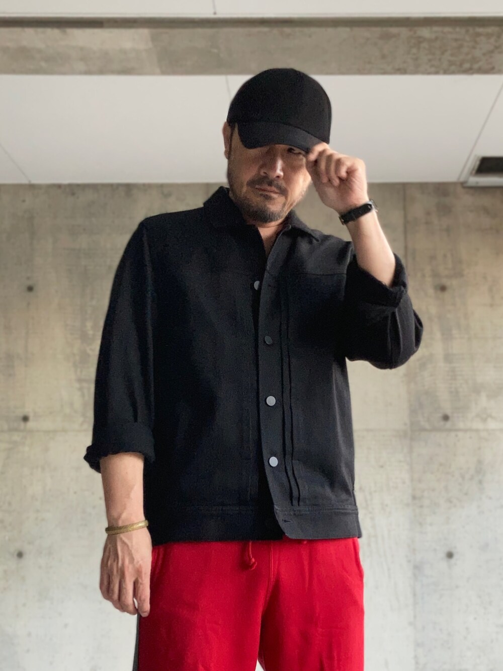 ブラック系のデニムジャケット、レッド系のスウェットパンツ、ブラック系のローファーを着用したメンズの夏コーディネートの5枚目の写真