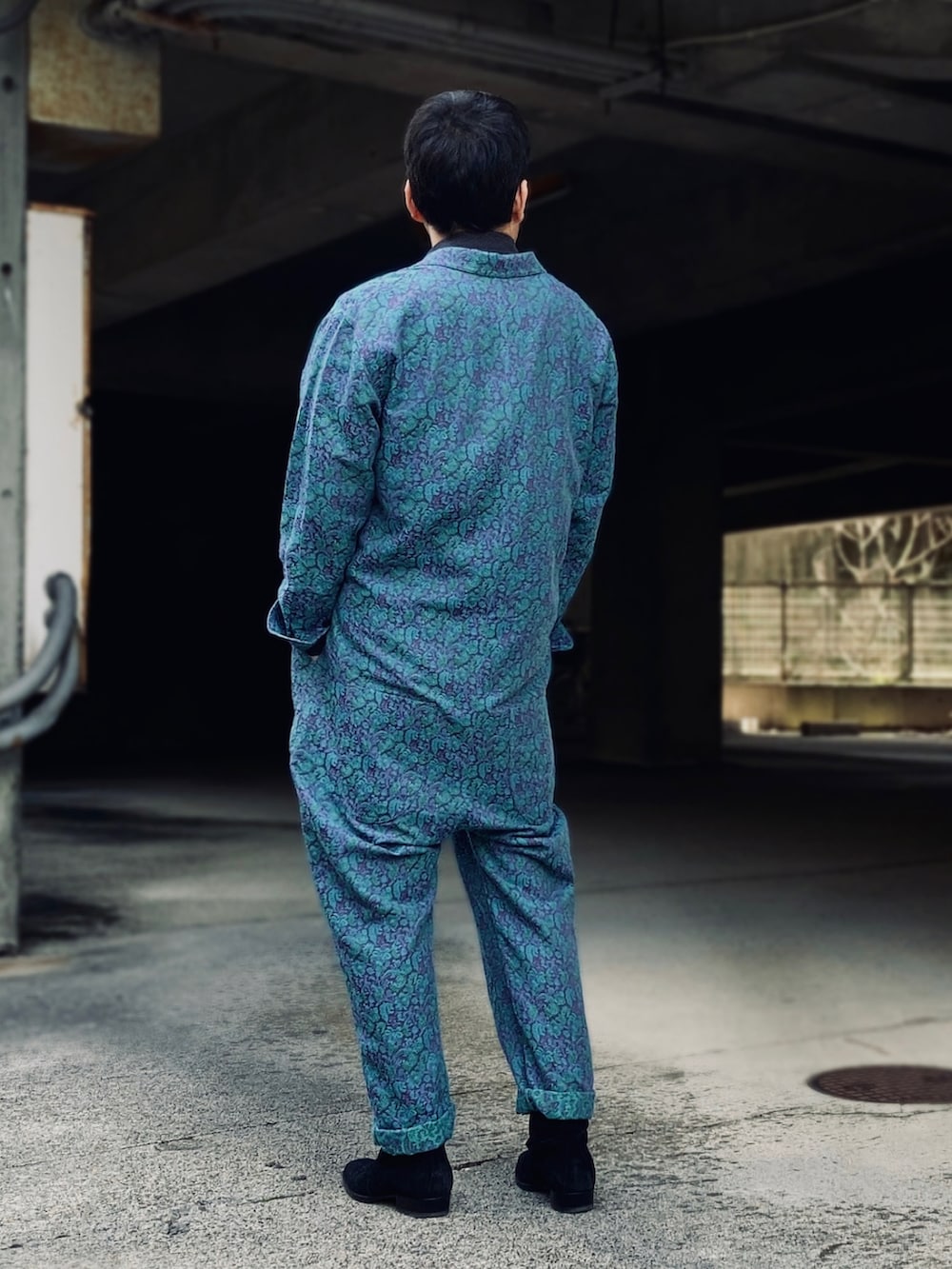 ブラック系のポロシャツ、ブルー系のつなぎ/オールインワン、ブラック系のブーツを着用したメンズの春コーディネートの3枚目の写真