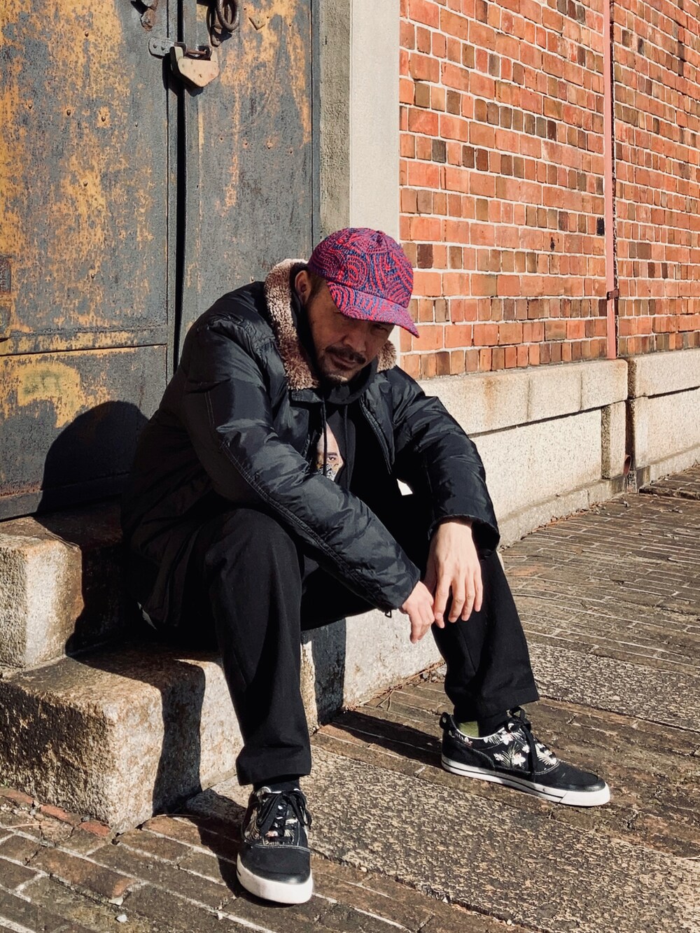 ブラック系のパーカー、ブラック系のダウンジャケット/コート、ブラック系のパンツを着用したメンズの冬コーディネートの5枚目の写真