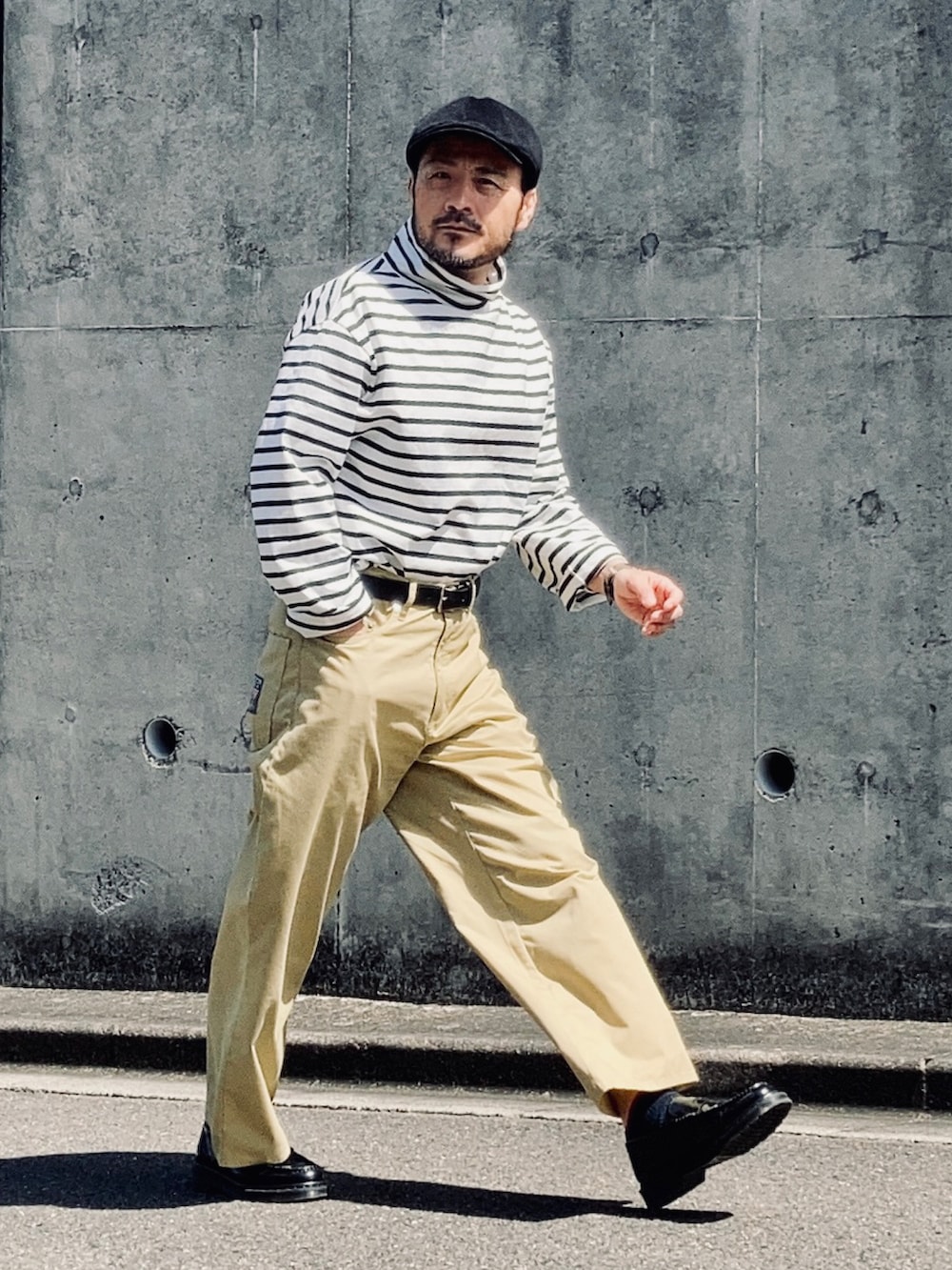 ブラック系のTシャツ/カットソー、ベージュ系のチノパンツ、ブラック系のローファーを着用したメンズの春コーディネートの2枚目の写真