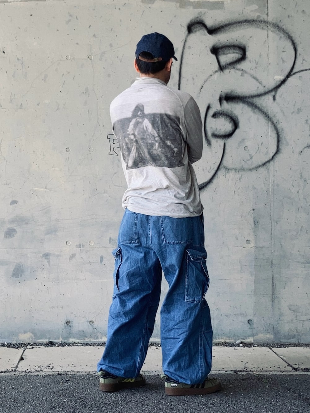 グレー系のTシャツ/カットソー、ブルー系のカーゴパンツ、グリーン系のスニーカーを着用したメンズの春コーディネートの4枚目の写真