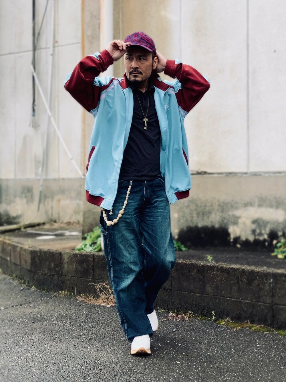 ブラック系のポロシャツ、ブルー系のその他アウター、ブルー系のデニムパンツを着用したメンズの春コーディネートの3枚目の写真