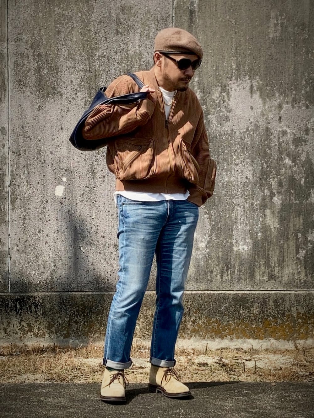 ホワイト系のTシャツ/カットソー、ブラウン系のMA-1、ブルー系のデニムパンツを着用したメンズの秋コーディネートの3枚目の写真