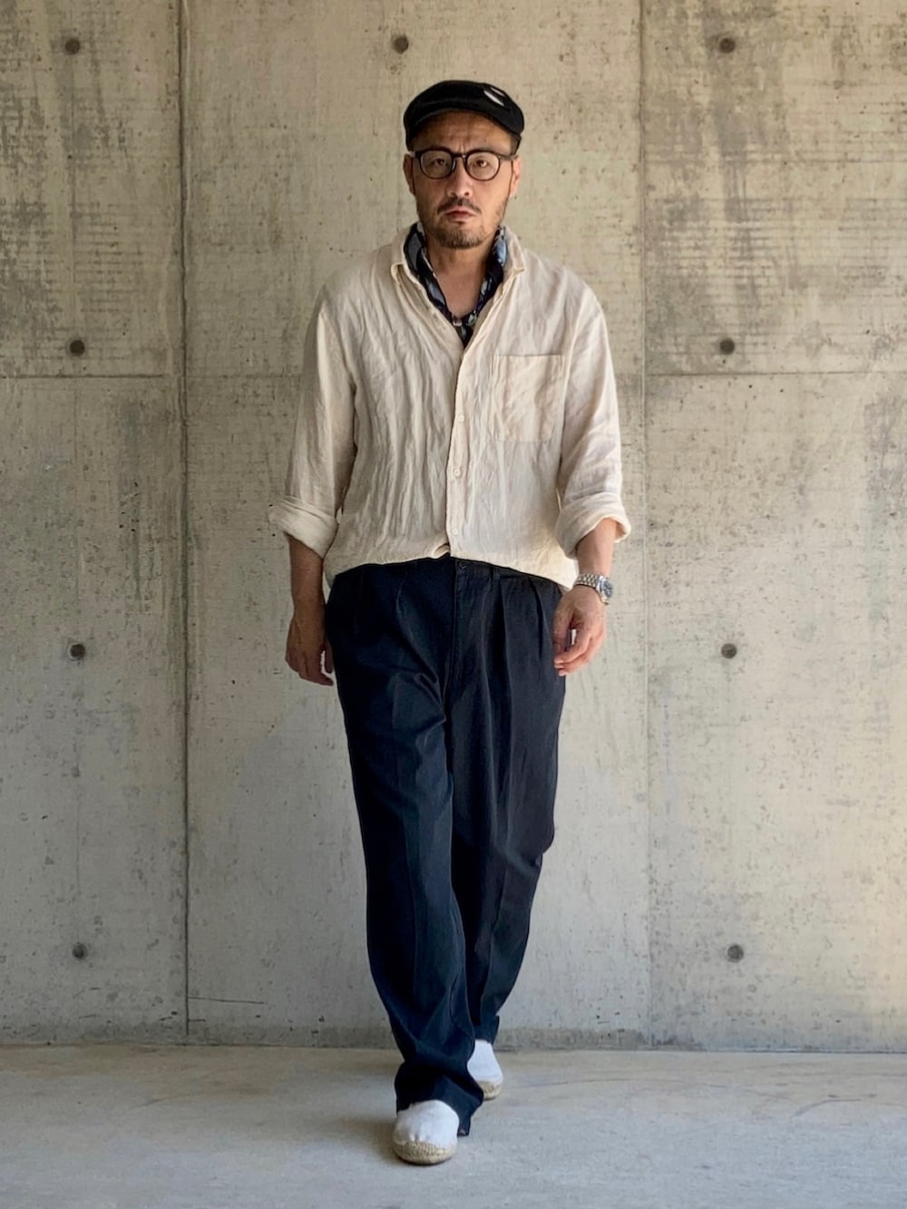 ベージュ系のシャツ/ブラウス、ブルー系のチノパンツ、ホワイト系のスリッポンを着用したメンズの夏コーディネートの4枚目の写真