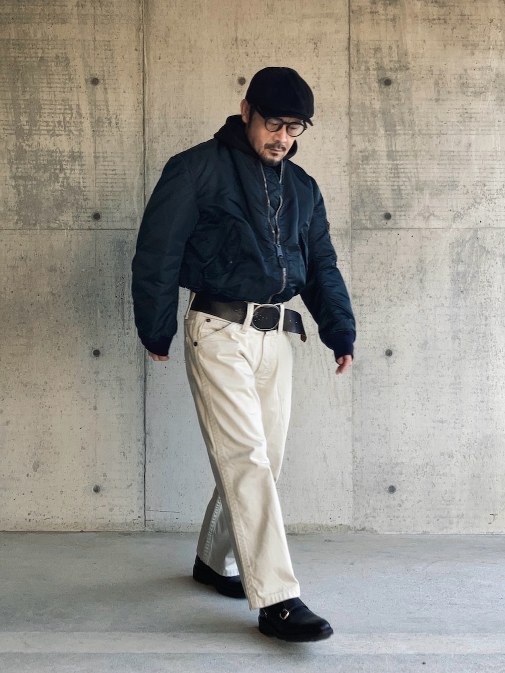 ホワイト系のデニムパンツ、ブラック系のパーカー、ブルー系のMA-1を着用したメンズの冬コーディネートの3枚目の写真