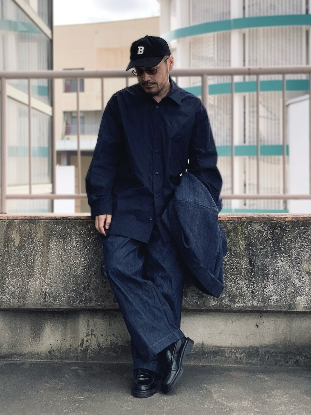 ブラック系のシャツ/ブラウス、ブルー系のデニムパンツ、ブラック系のローファーを着用したメンズの冬コーディネートの2枚目の写真