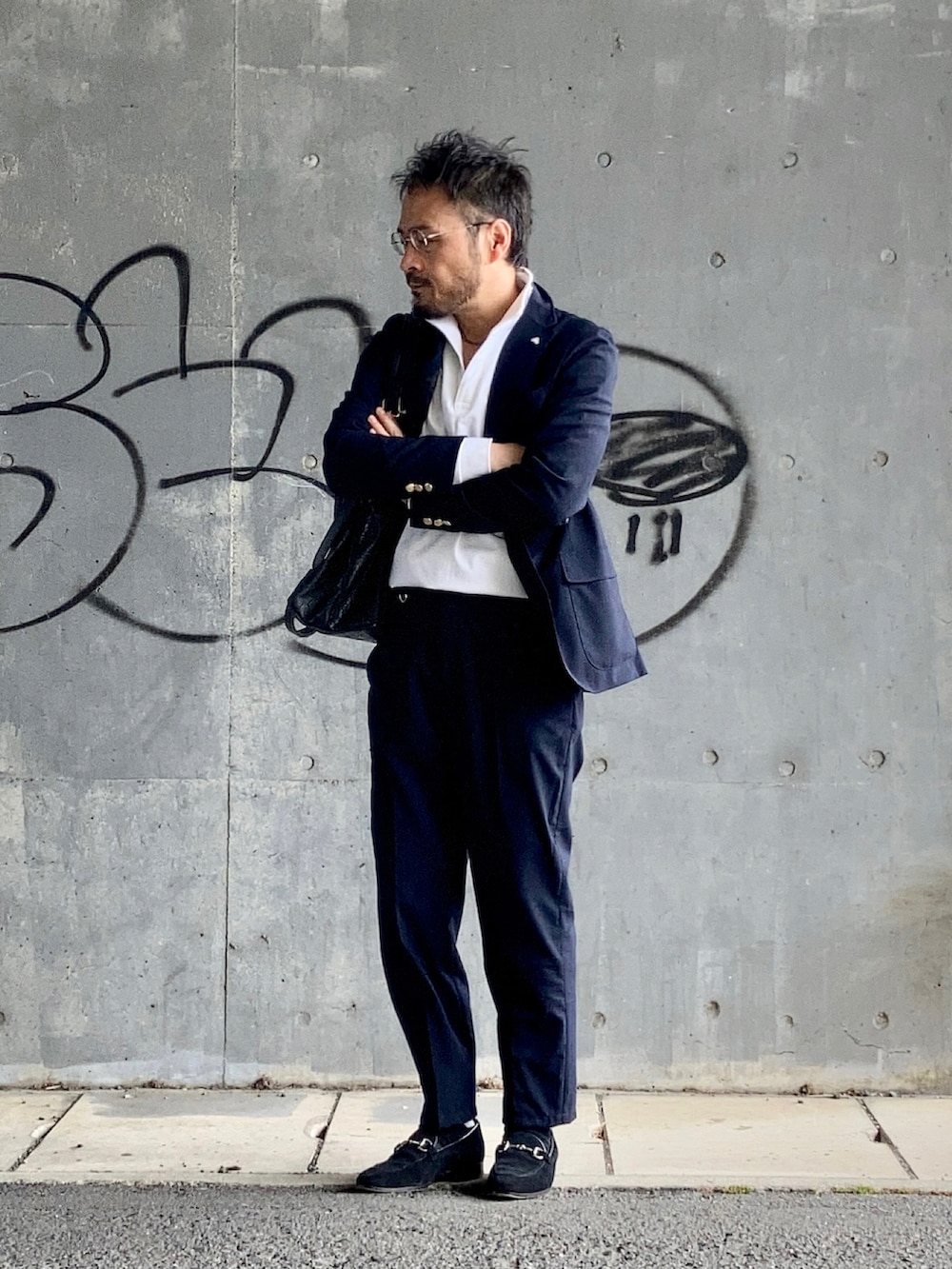 ホワイト系のポロシャツ、ブルー系のテーラードジャケット、ブルー系のスラックスを着用したメンズの春コーディネートの2枚目の写真