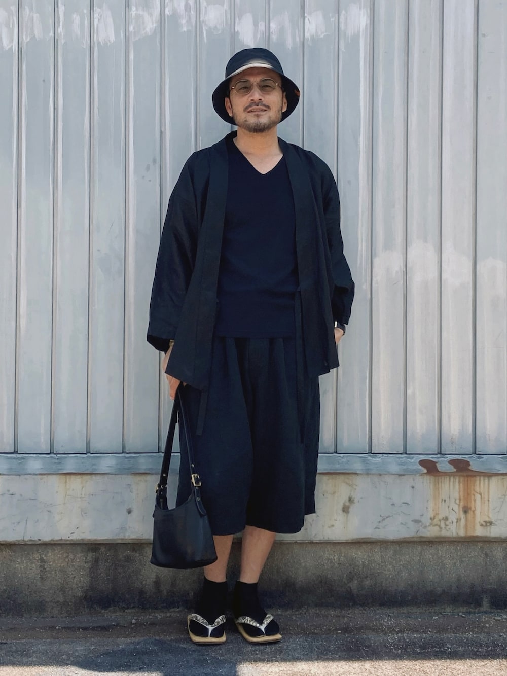 ブラック系のTシャツ/カットソー、ブラック系のその他パンツ、ベージュ系のサンダルを着用したメンズの夏コーディネートの3枚目の写真