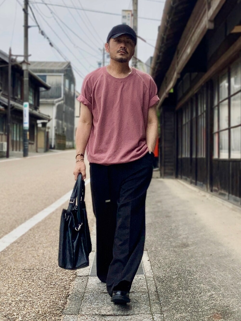 ピンク系のTシャツ/カットソー、ブラック系のスラックス、ブラック系のローファーを着用したメンズの夏コーディネートの2枚目の写真