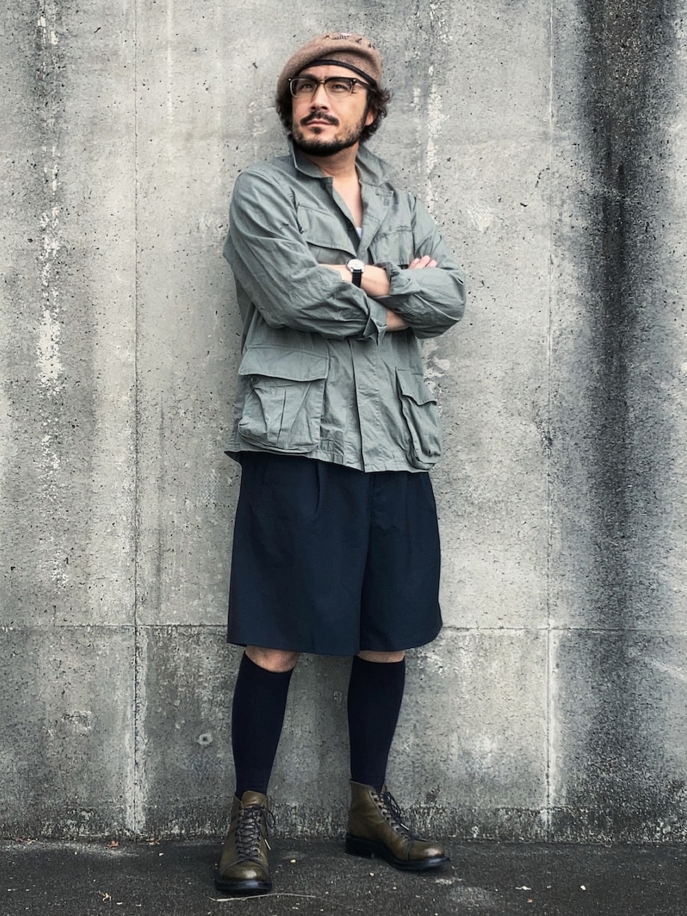 グリーン系のミリタリージャケット、ブルー系のスラックス、グリーン系のブーツを着用したメンズの秋コーディネートの2枚目の写真