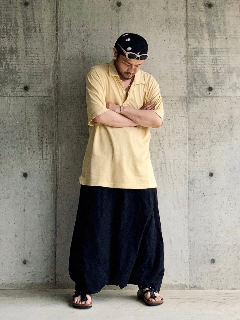 イエロー系のポロシャツ、ブラック系のその他パンツ、ブラック系のサンダルを着用したメンズの夏コーディネートの2枚目の写真