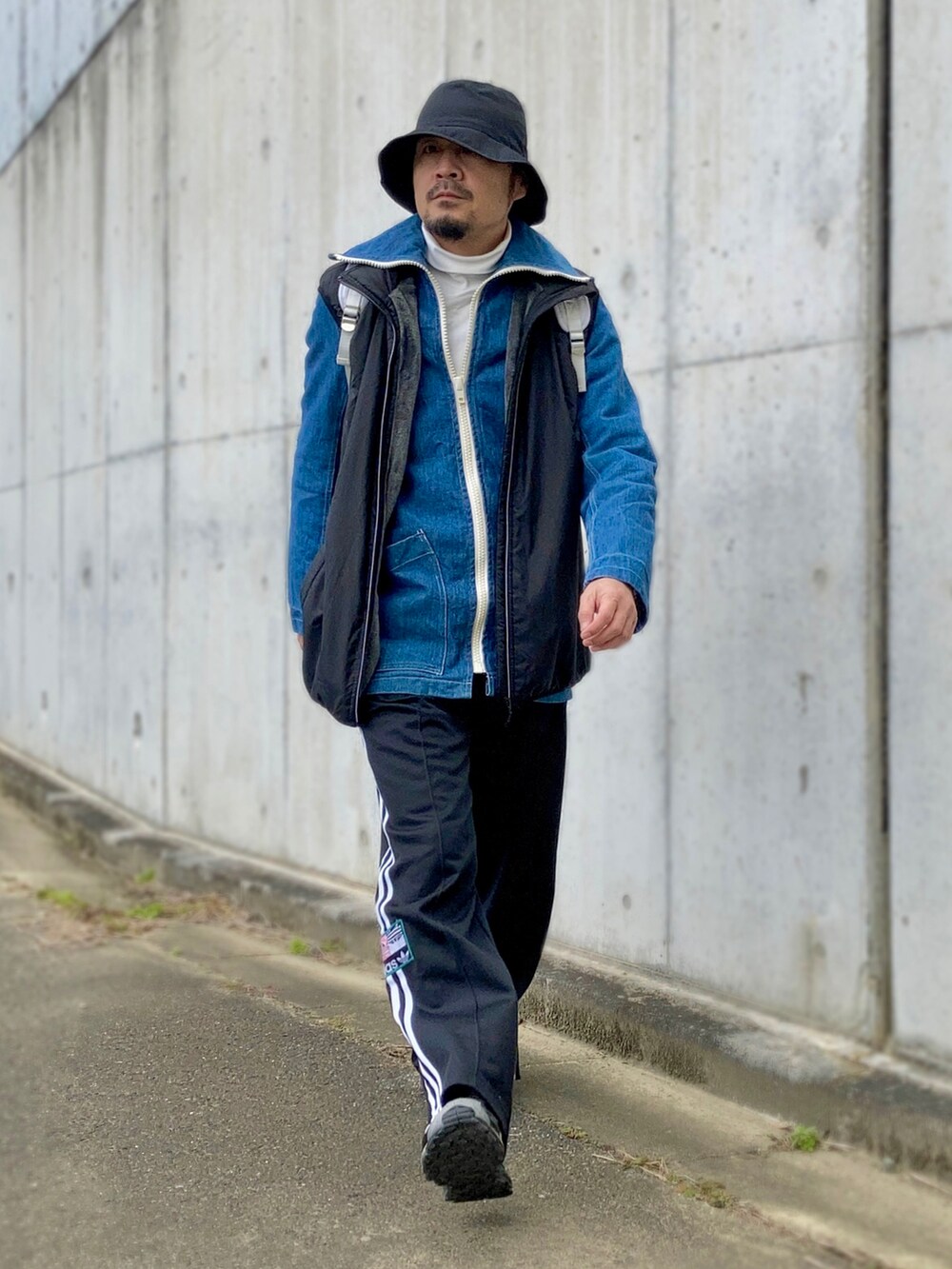 ホワイト系のTシャツ/カットソー、ブルー系のデニムジャケット、ブラック系のベストを着用したメンズの冬コーディネートの2枚目の写真