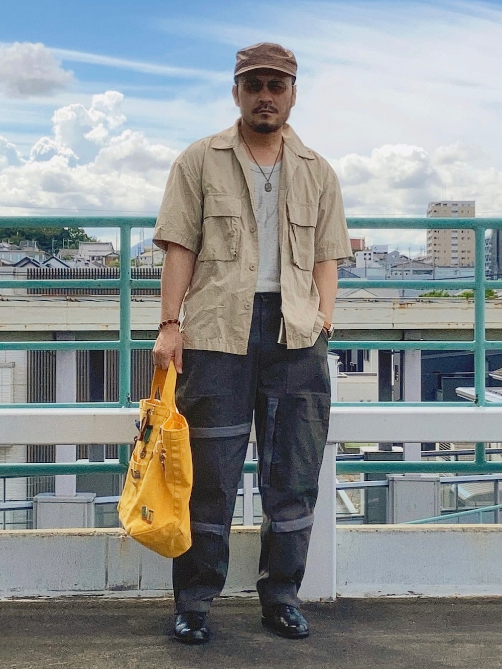 グレー系のタンクトップ、ベージュ系のシャツ/ブラウス、グリーン系のその他パンツを着用したメンズの夏コーディネートの2枚目の写真