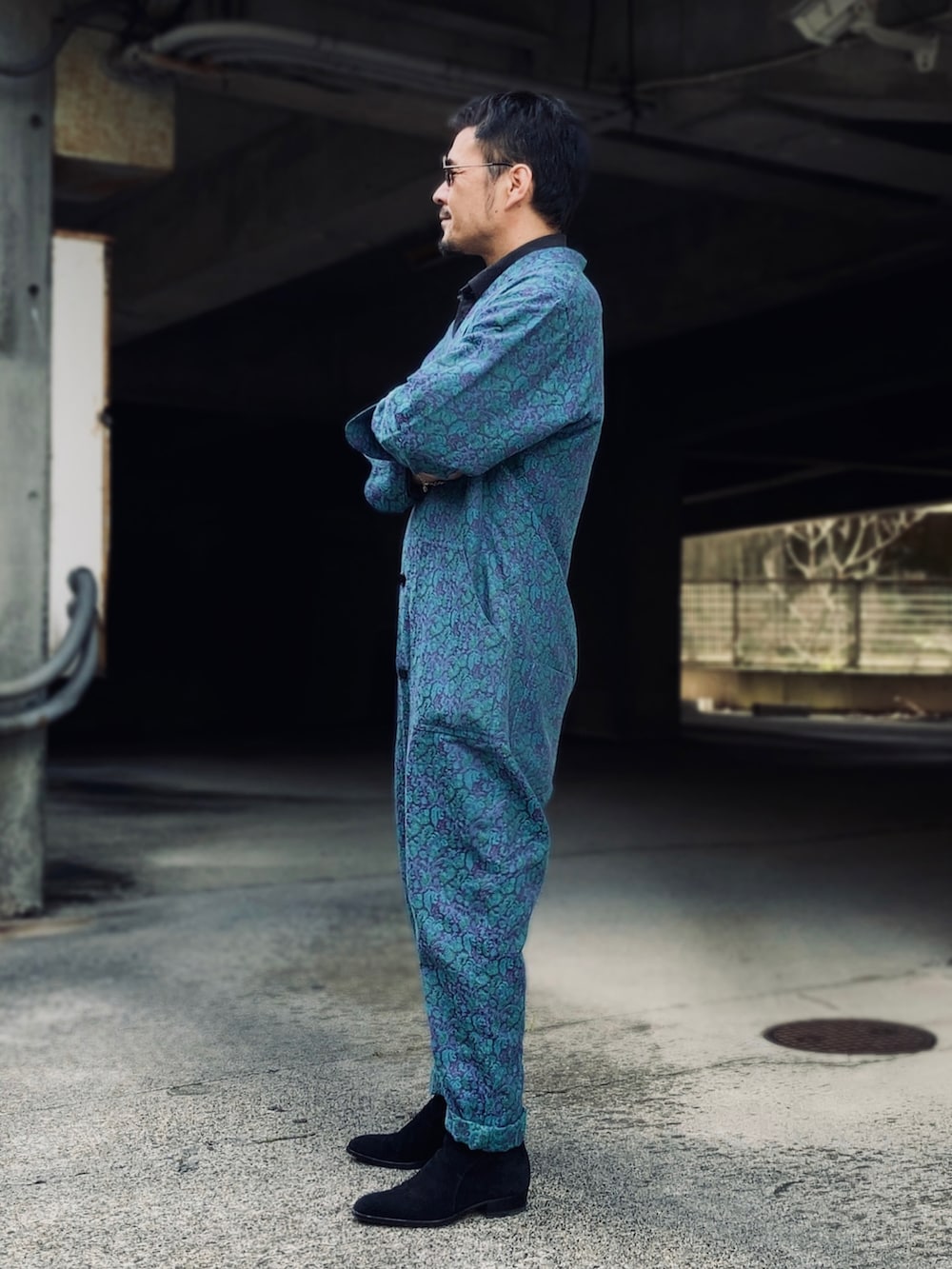 ブラック系のポロシャツ、ブルー系のつなぎ/オールインワン、ブラック系のブーツを着用したメンズの春コーディネートの4枚目の写真