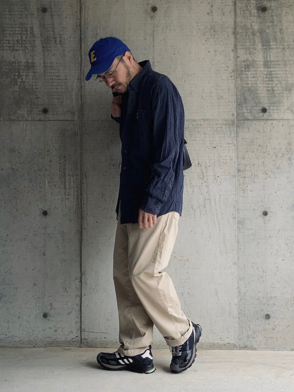 ブルー系のシャツ/ブラウス、ベージュ系のチノパンツ、ブラック系のスニーカーを着用したメンズの秋コーディネートの3枚目の写真