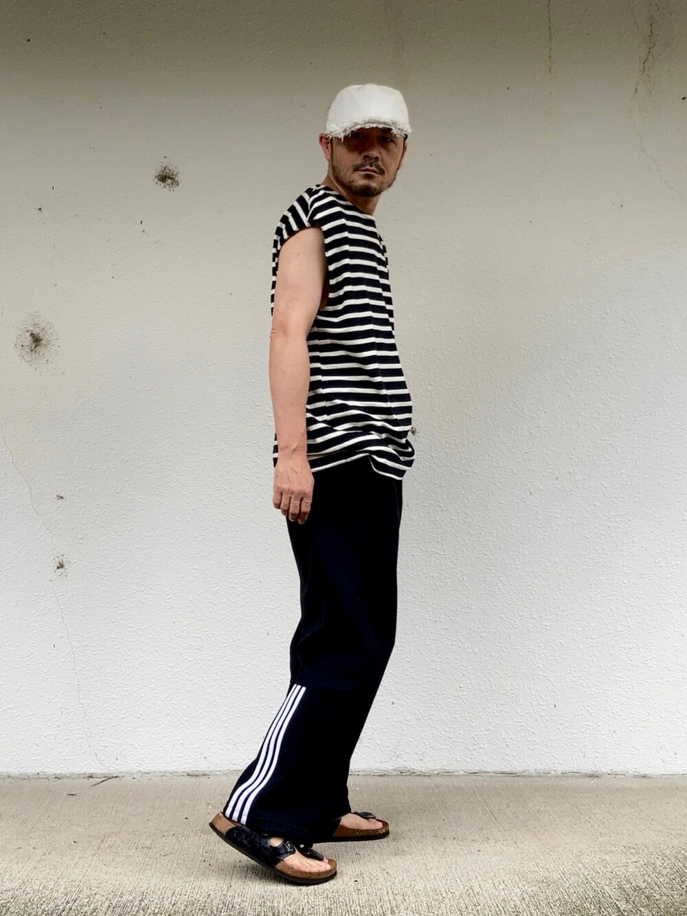 ブラック系のTシャツ/カットソー、ブラック系のパンツ、ブラック系のサンダルを着用したメンズの夏コーディネートの3枚目の写真