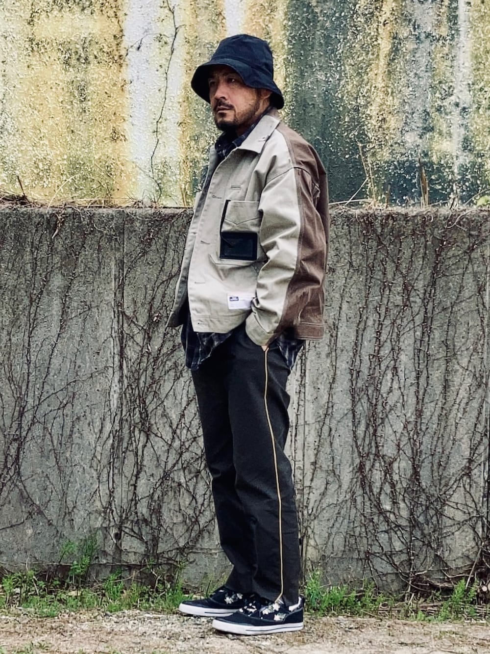 グレー系のシャツ/ブラウス、ベージュ系のその他アウター、グリーン系のスラックスを着用したメンズの春コーディネートの2枚目の写真