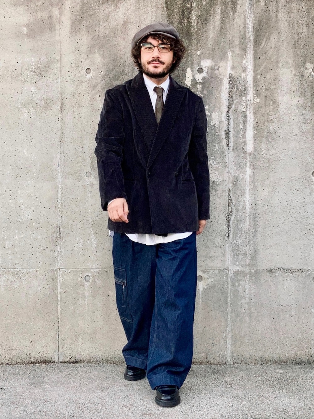 グレー系のテーラードジャケット、ブルー系のデニムパンツ、ブラック系のローファーを着用したメンズの秋コーディネートの2枚目の写真