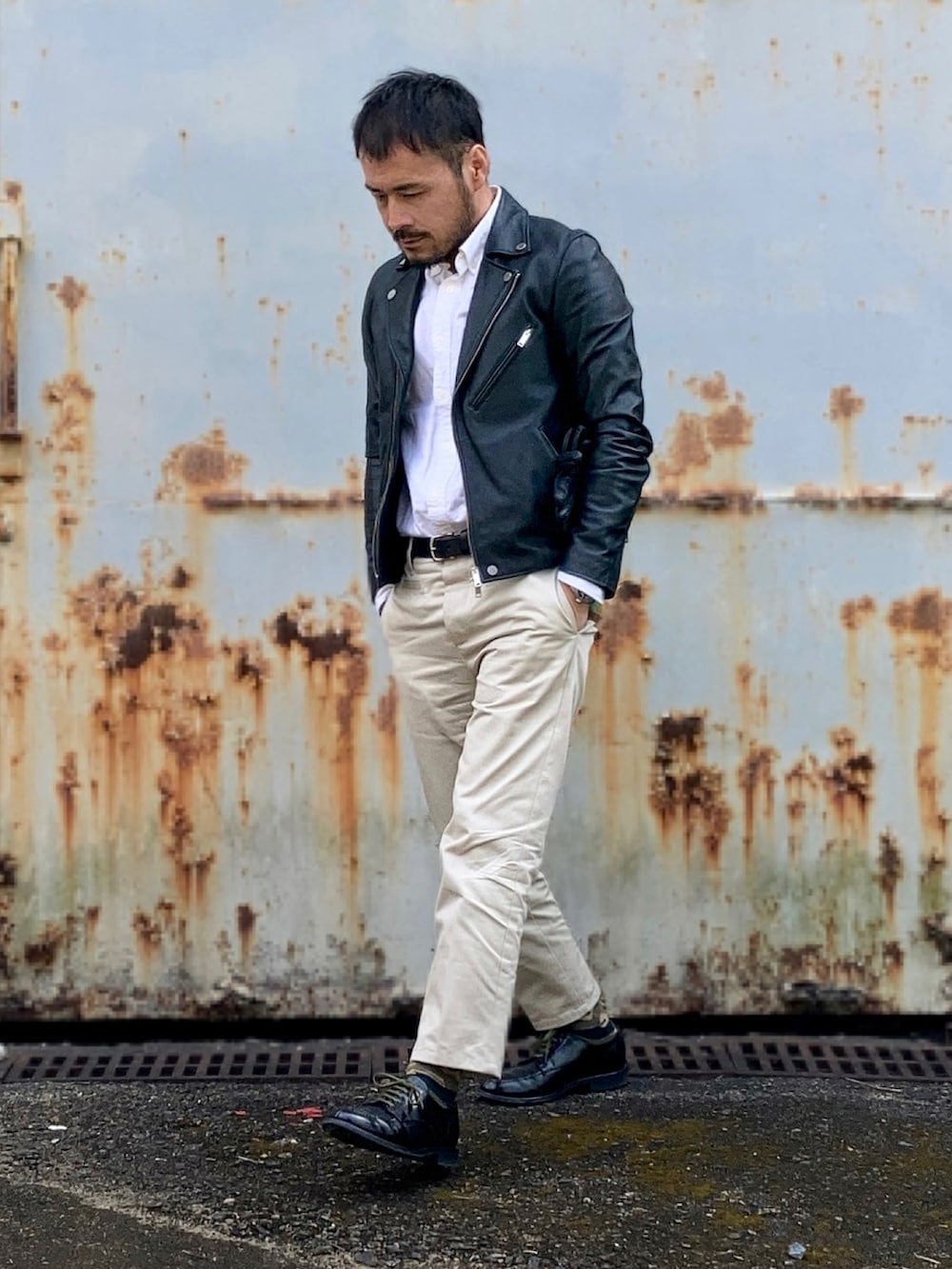 ホワイト系のシャツ/ブラウス、ブラック系のライダースジャケット、ベージュ系のチノパンツを着用したメンズの冬コーディネートの2枚目の写真