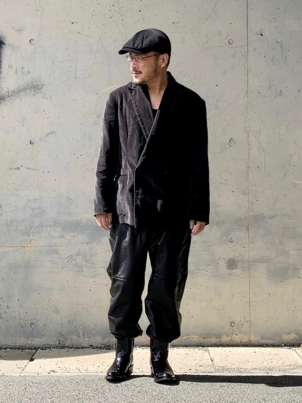 グレー系のテーラードジャケット、ブラック系のその他パンツ、ブラック系のブーツを着用したメンズの秋コーディネートの2枚目の写真