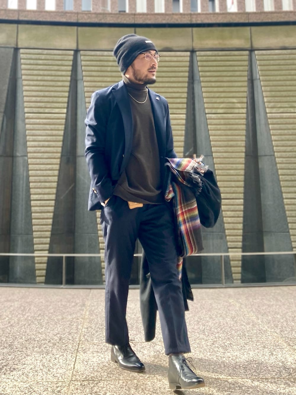 ブラウン系のニット/セーター、ブルー系のテーラードジャケット、ブルー系のスラックスを着用したメンズの冬コーディネートの2枚目の写真