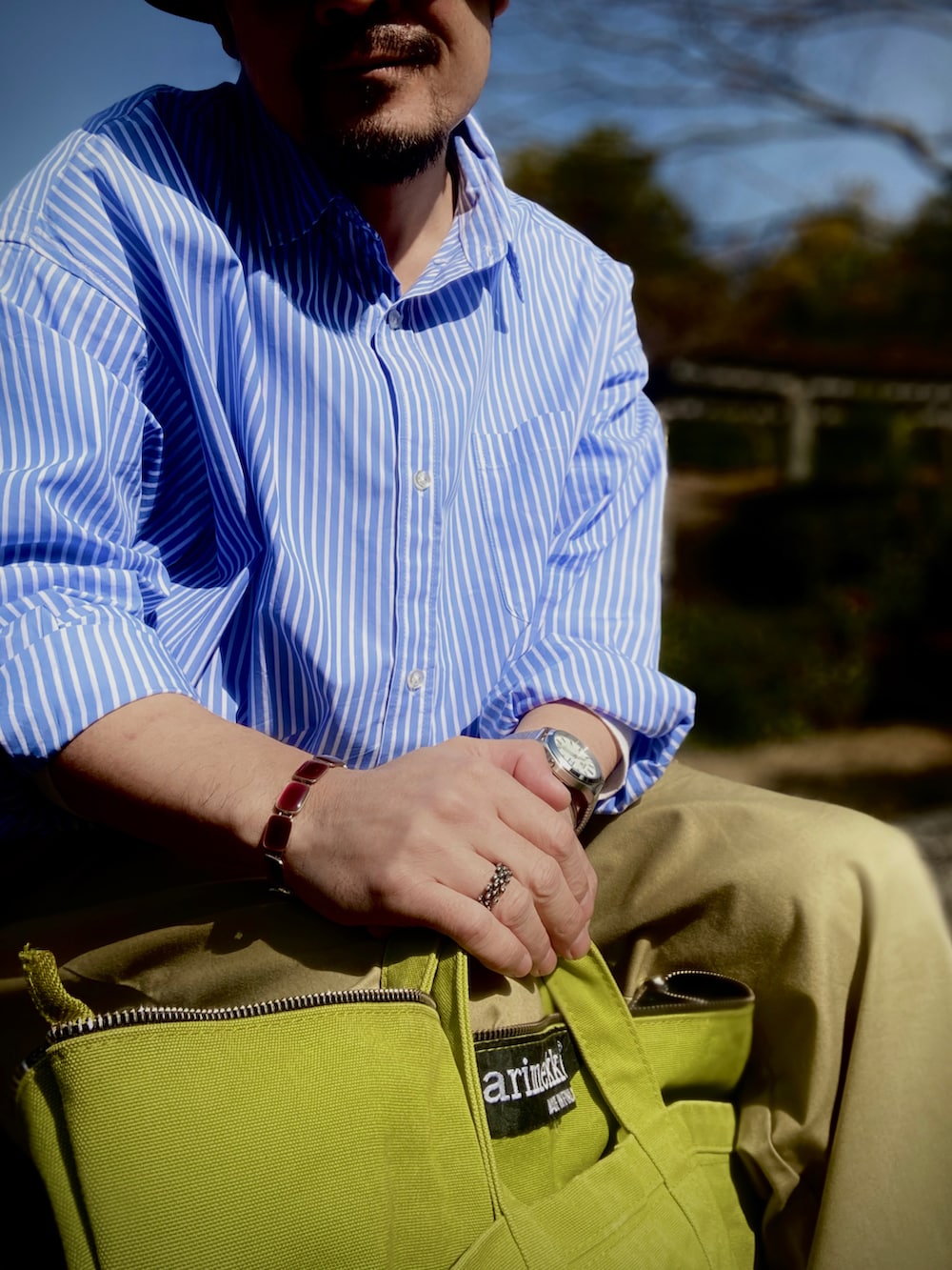 ブルー系のシャツ/ブラウス、ベージュ系のチノパンツ、ブルー系のスニーカーを着用したメンズの春コーディネートの4枚目の写真