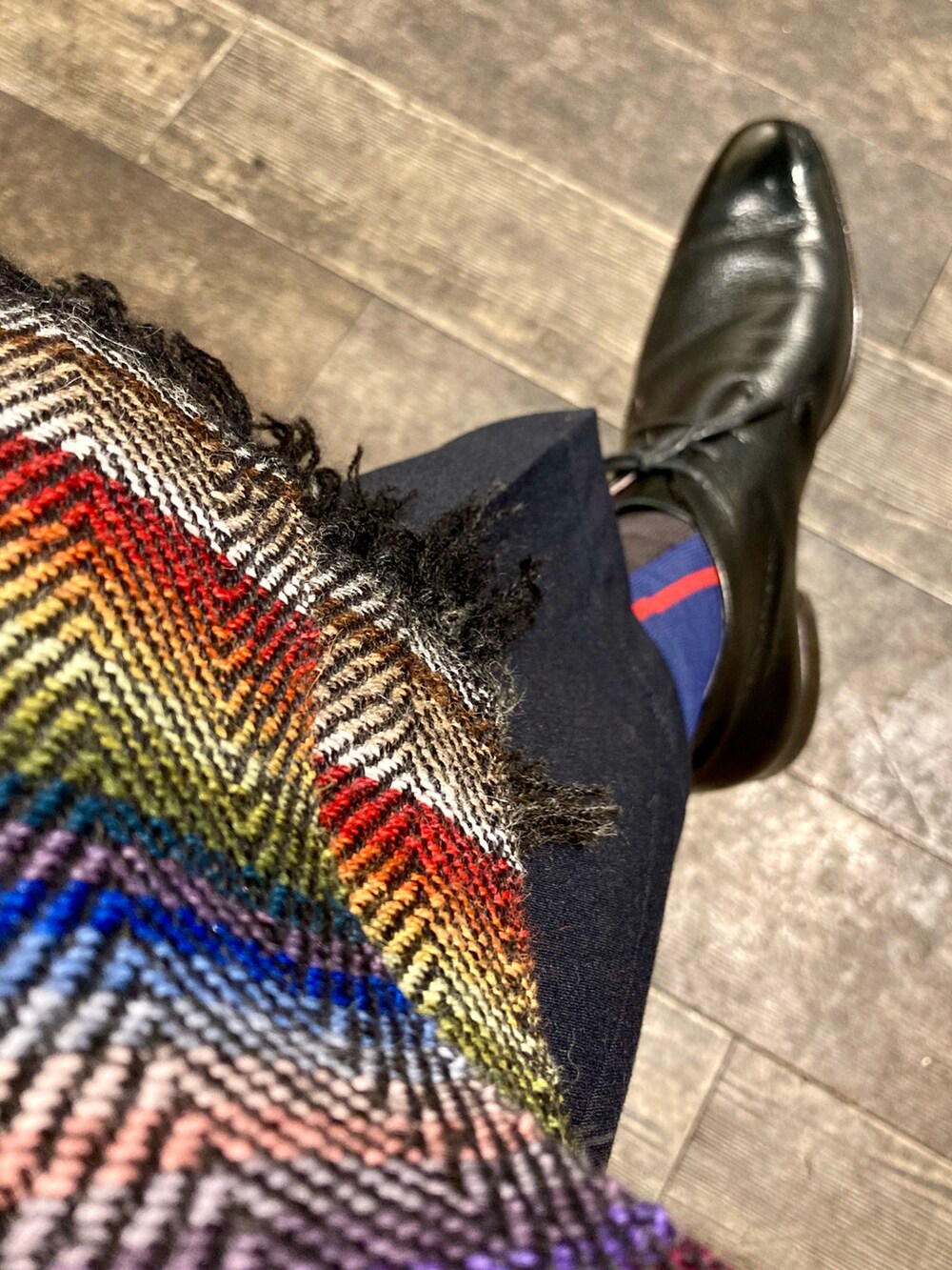 ブラック系のチェスターコート、ブルー系のテーラードジャケット、ブルー系のスラックスを着用したメンズの冬コーディネートの3枚目の写真