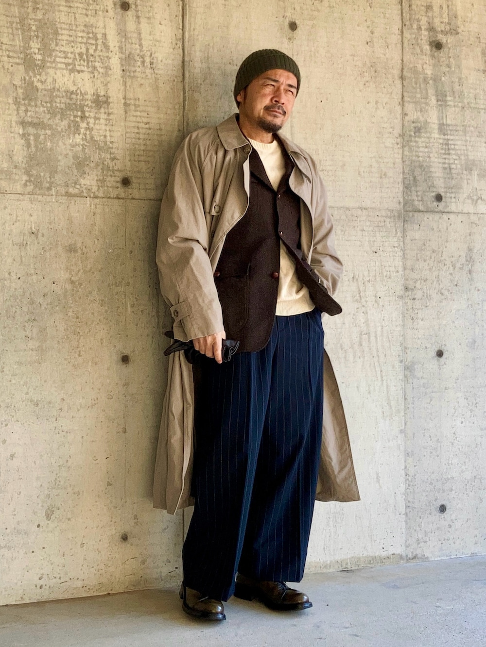 ブラウン系のテーラードジャケット、ベージュ系のトレンチコート、ブルー系のスラックスを着用したメンズの冬コーディネートの2枚目の写真