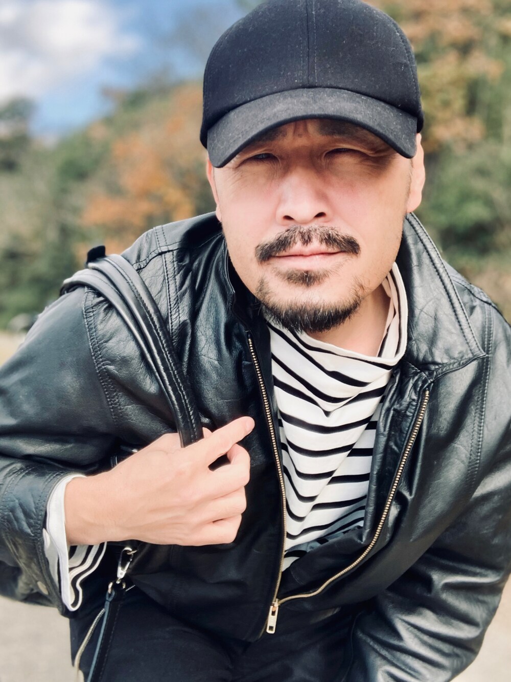ブラック系のTシャツ/カットソー、ブラック系のブルゾン、ブラック系のスラックスを着用したメンズの冬コーディネートの5枚目の写真