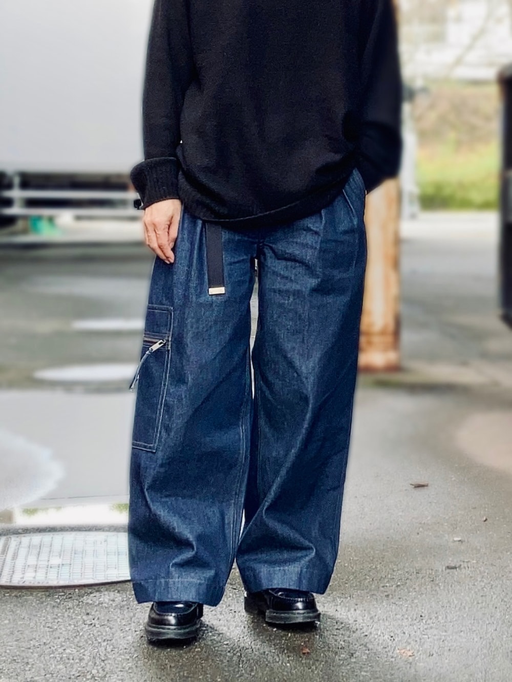 ブラック系のニット/セーター、ブルー系のデニムパンツ、ブラック系のローファーを着用したメンズの秋コーディネートの3枚目の写真