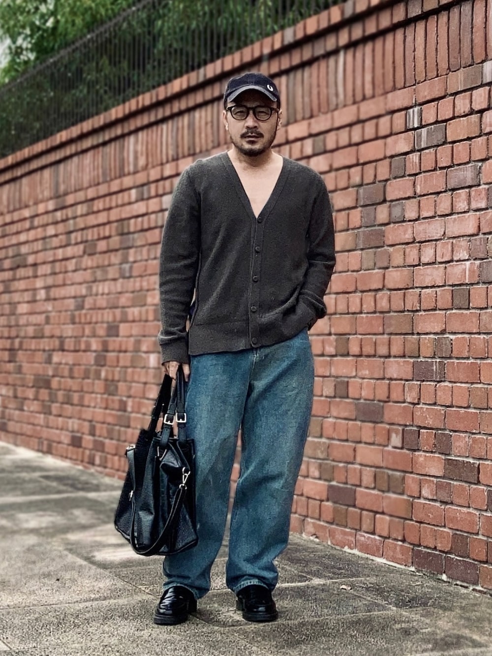 グレー系のカーディガン/ボレロ、ブルー系のデニムパンツ、ブラック系のローファーを着用したメンズの秋コーディネートの3枚目の写真