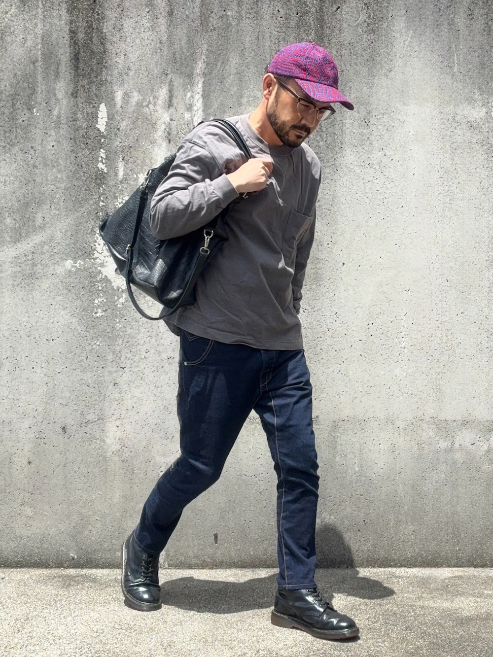 グレー系のTシャツ/カットソー、ブルー系のデニムパンツ、ブラック系のトートバッグを着用したメンズの春コーディネートの2枚目の写真