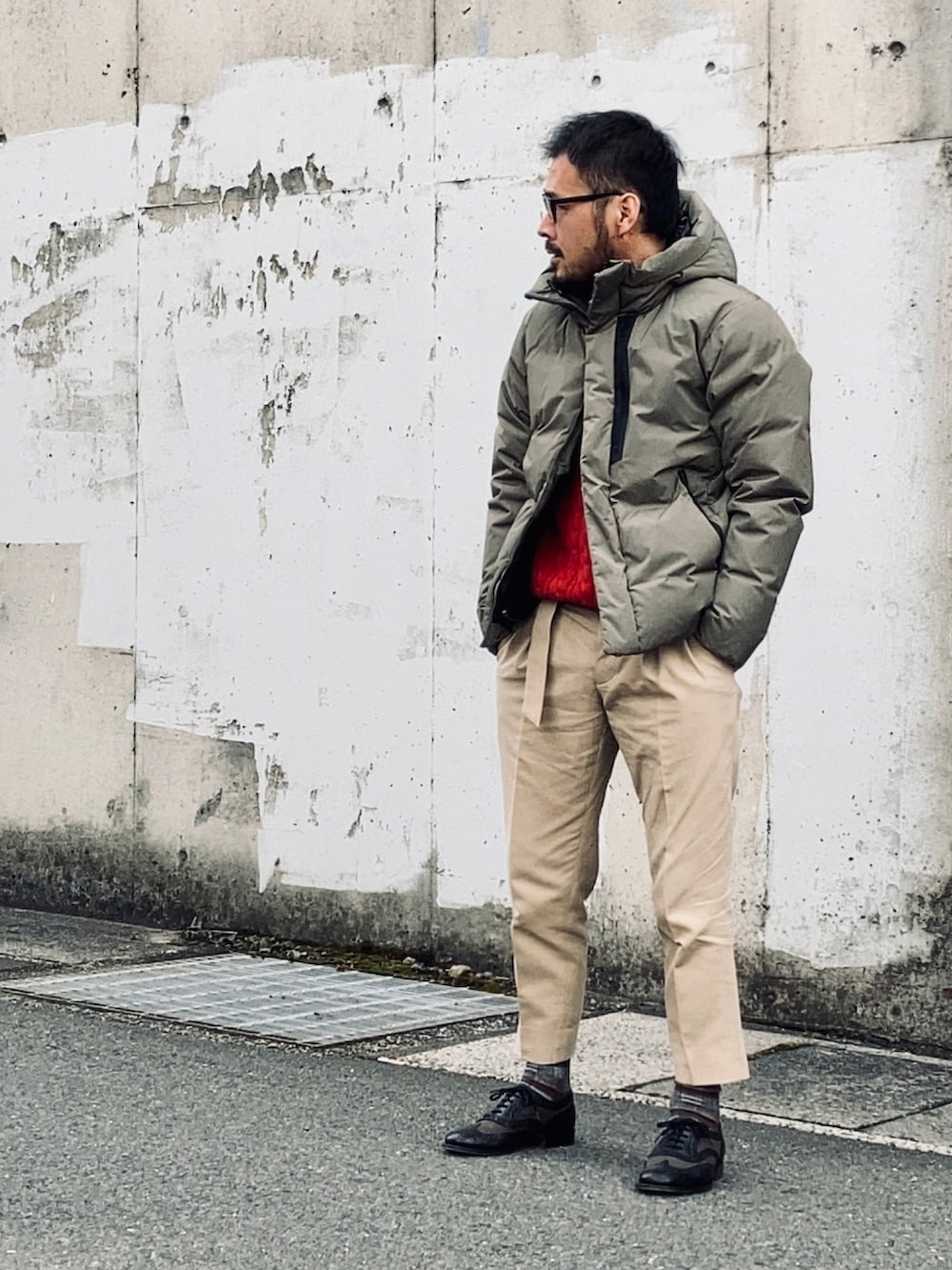 レッド系のニット/セーター、グレー系のジャケット/アウター、ベージュ系のスラックスを着用したメンズの冬コーディネートの3枚目の写真