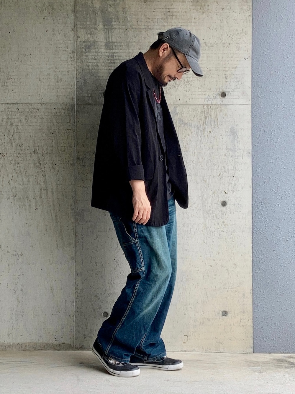 ブラック系のTシャツ/カットソー、ブラック系のテーラードジャケット、ブルー系のデニムパンツを着用したメンズの夏コーディネートの3枚目の写真