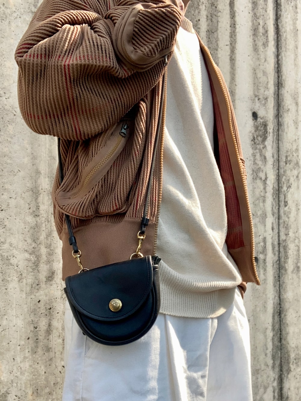 ベージュ系のニット/セーター、ブラウン系のMA-1、ホワイト系のスラックスを着用したメンズの春コーディネートの4枚目の写真