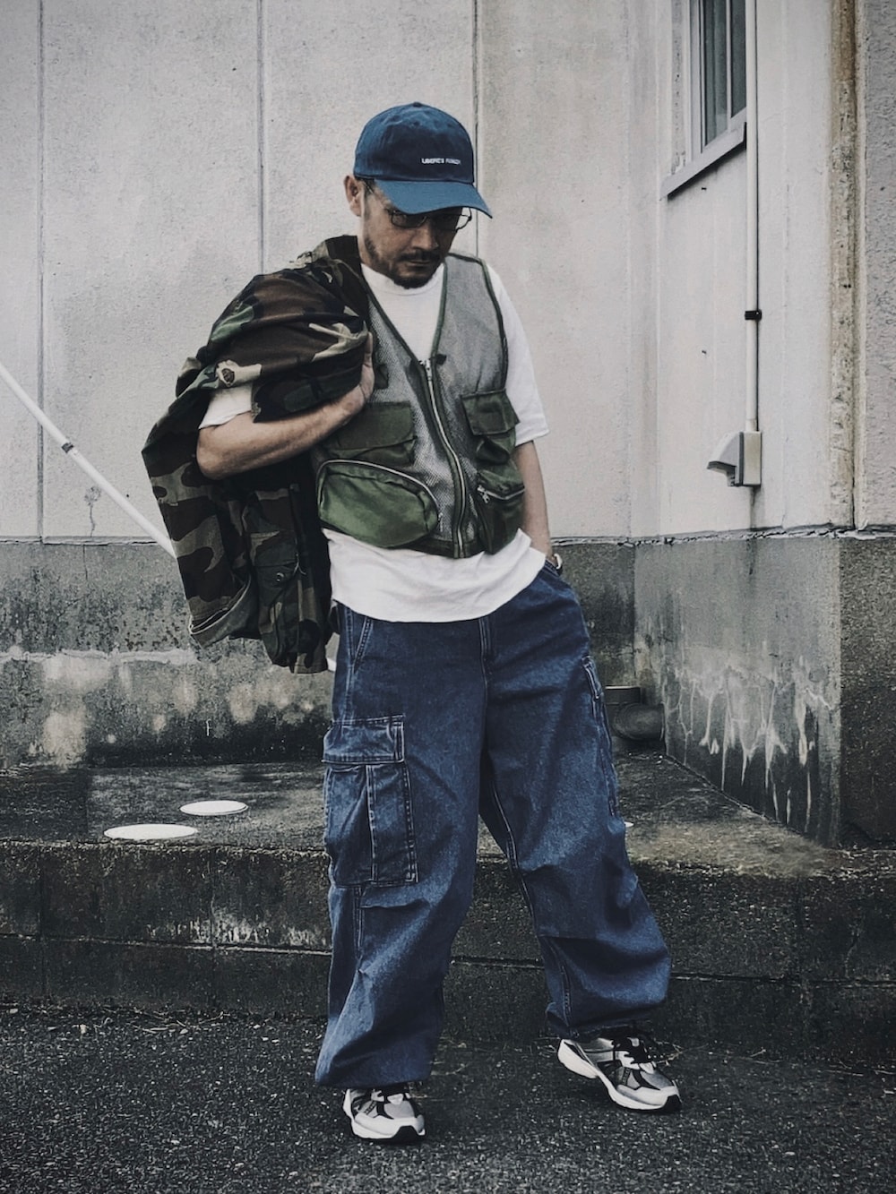 グリーン系のベスト、その他のミリタリージャケット、ブルー系のカーゴパンツを着用したメンズの秋コーディネートの4枚目の写真