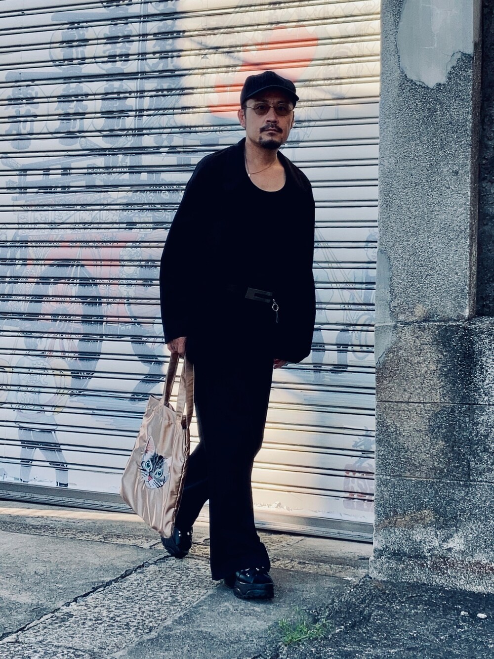 ブラック系のタンクトップ、ブラック系のテーラードジャケット、ブラック系のスラックスを着用したメンズの秋コーディネートの5枚目の写真