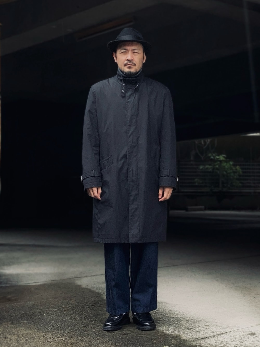 グレー系のTシャツ/カットソー、ブラック系のノーカラーコート、ブラック系のベストを着用したメンズの冬コーディネートの2枚目の写真