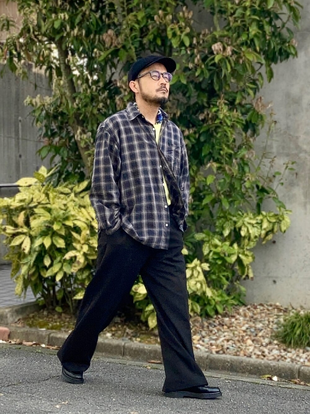 イエロー系のTシャツ/カットソー、グレー系のシャツ/ブラウス、ブラック系のスラックスを着用したメンズの春コーディネートの2枚目の写真