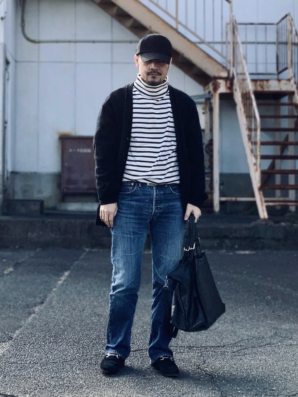 ブラック系のTシャツ/カットソー、ブラック系のカーディガン/ボレロ、ブルー系のデニムパンツを着用したメンズの冬コーディネートの2枚目の写真